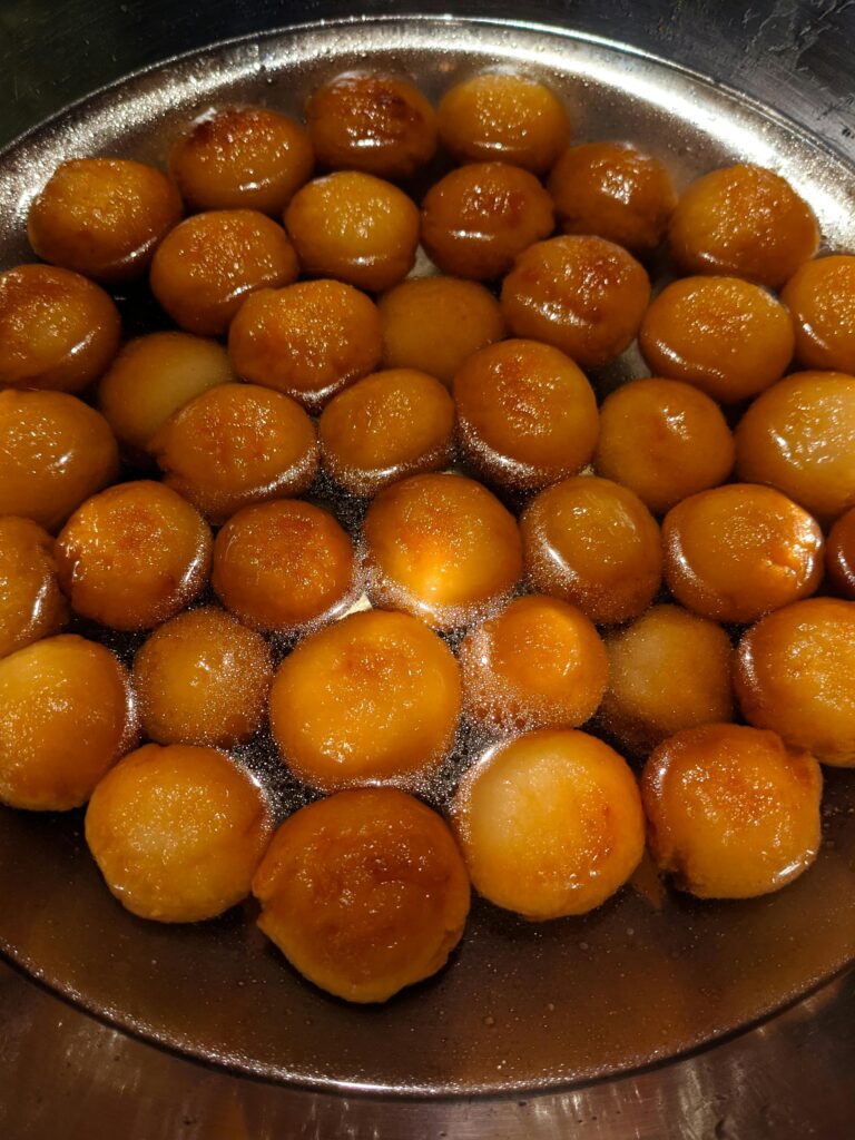 Delicious close-up of gulab jamun sweets in a stainless bowl, looking tasty and inviting.
